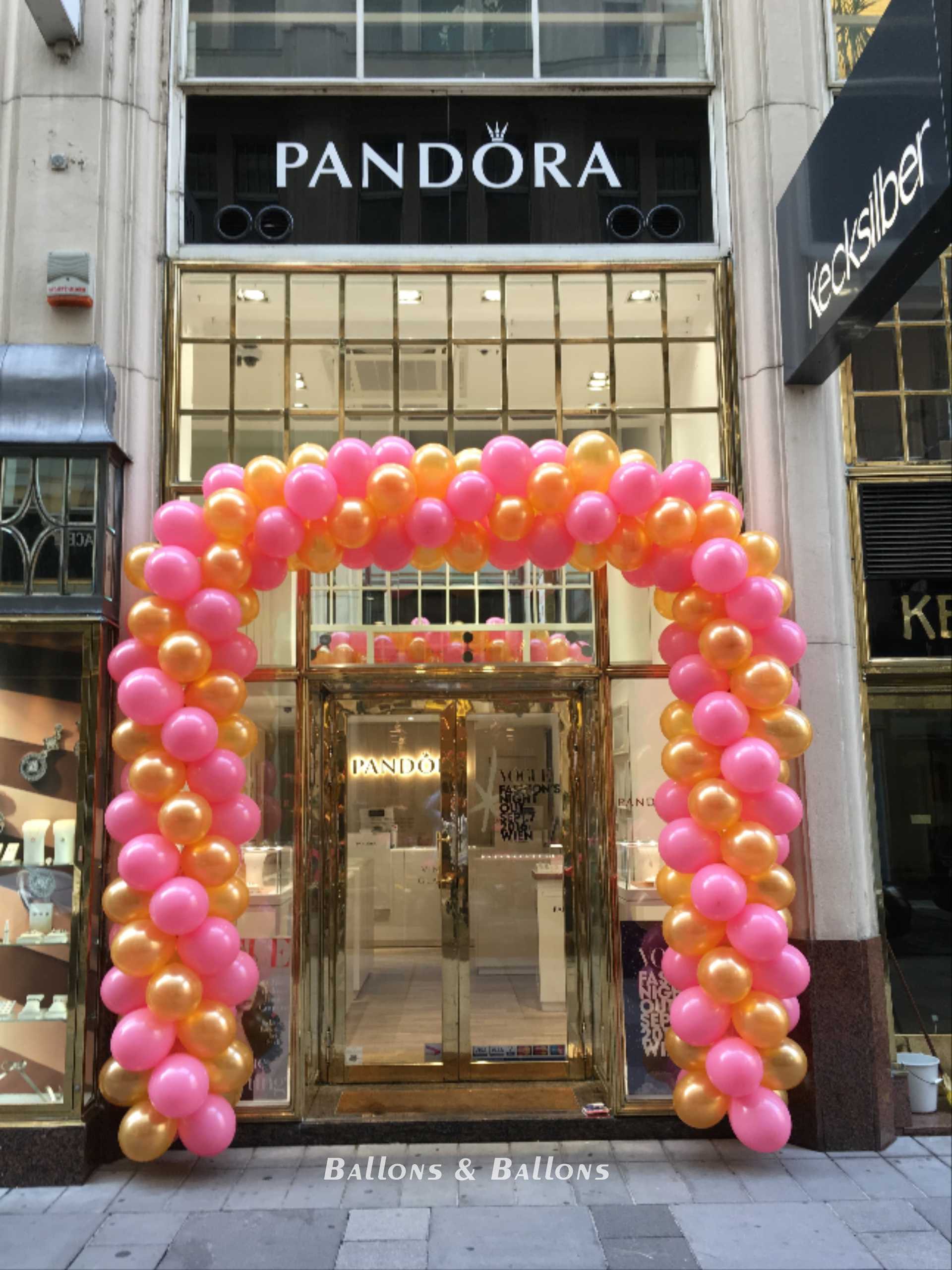 Ein rosa und gelber Luftballonbogen an einer Tür in Wien