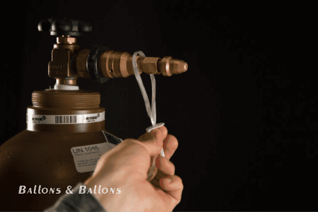 Eine Hand hält einen Ballon fest, während ein Ventil geschlossen wird in Wien.