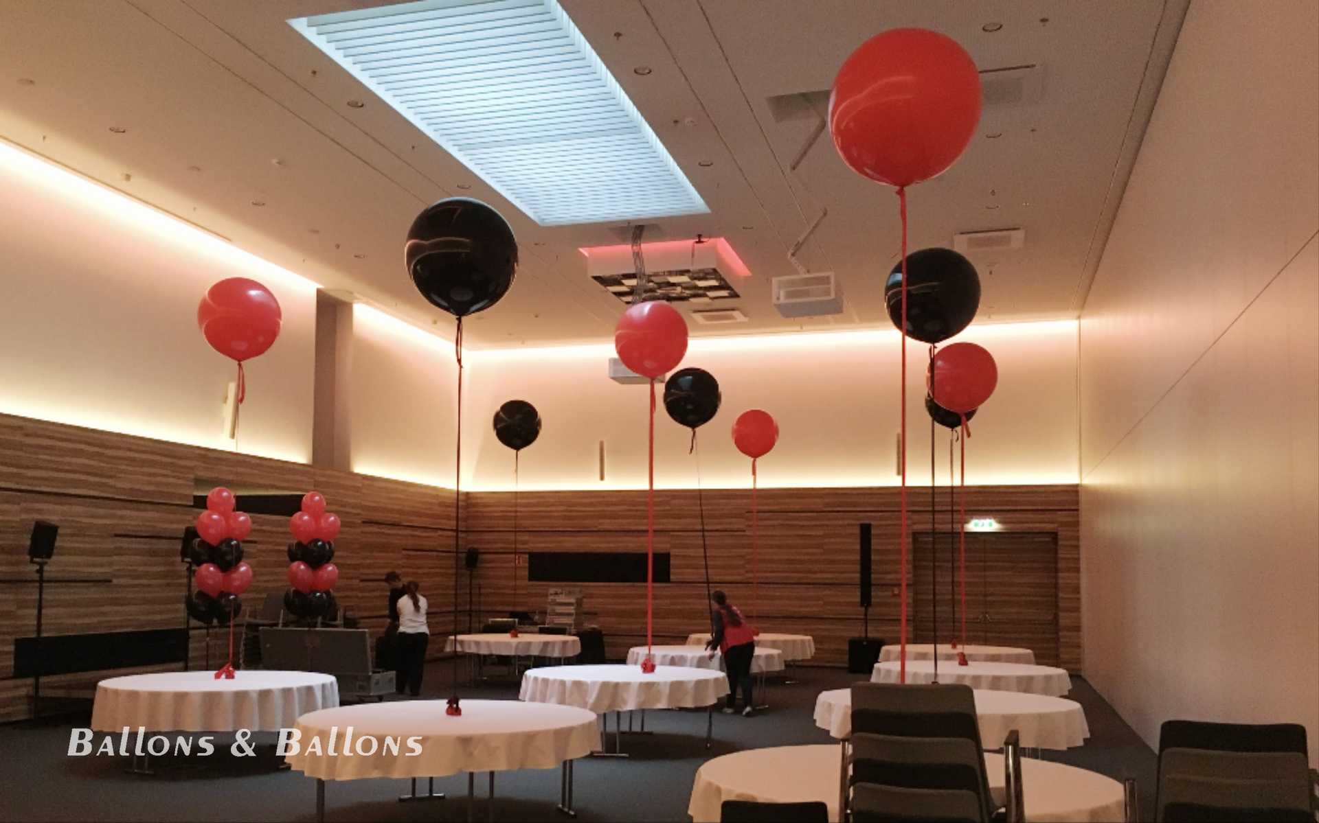 Tische mit Stühlen und Ballons in einem Veranstaltungsort in Wien.