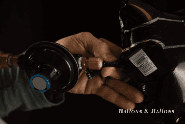 Eine Person setzt ein Metallventil auf einen Ballon in Wien.