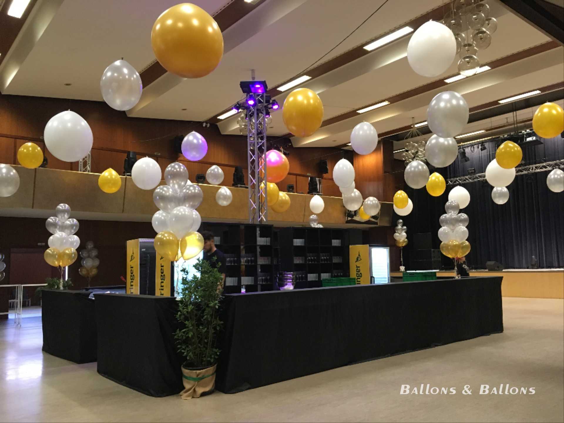 Eine festlich dekorierte Hochzeits-Empfangshalle mit gelben und weißen Ballons in Wien.