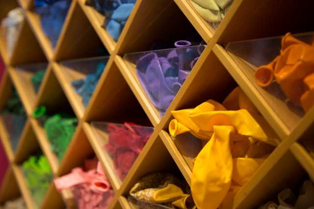 Buntes Sortiment an Gummibändern und Spielzeug auf einem Holzregal in Wien