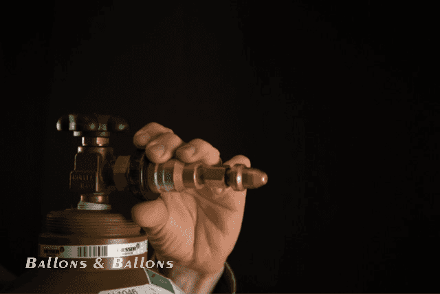 Eine Hand hält einen Gegenstand an eine Gasflasche in Wien.