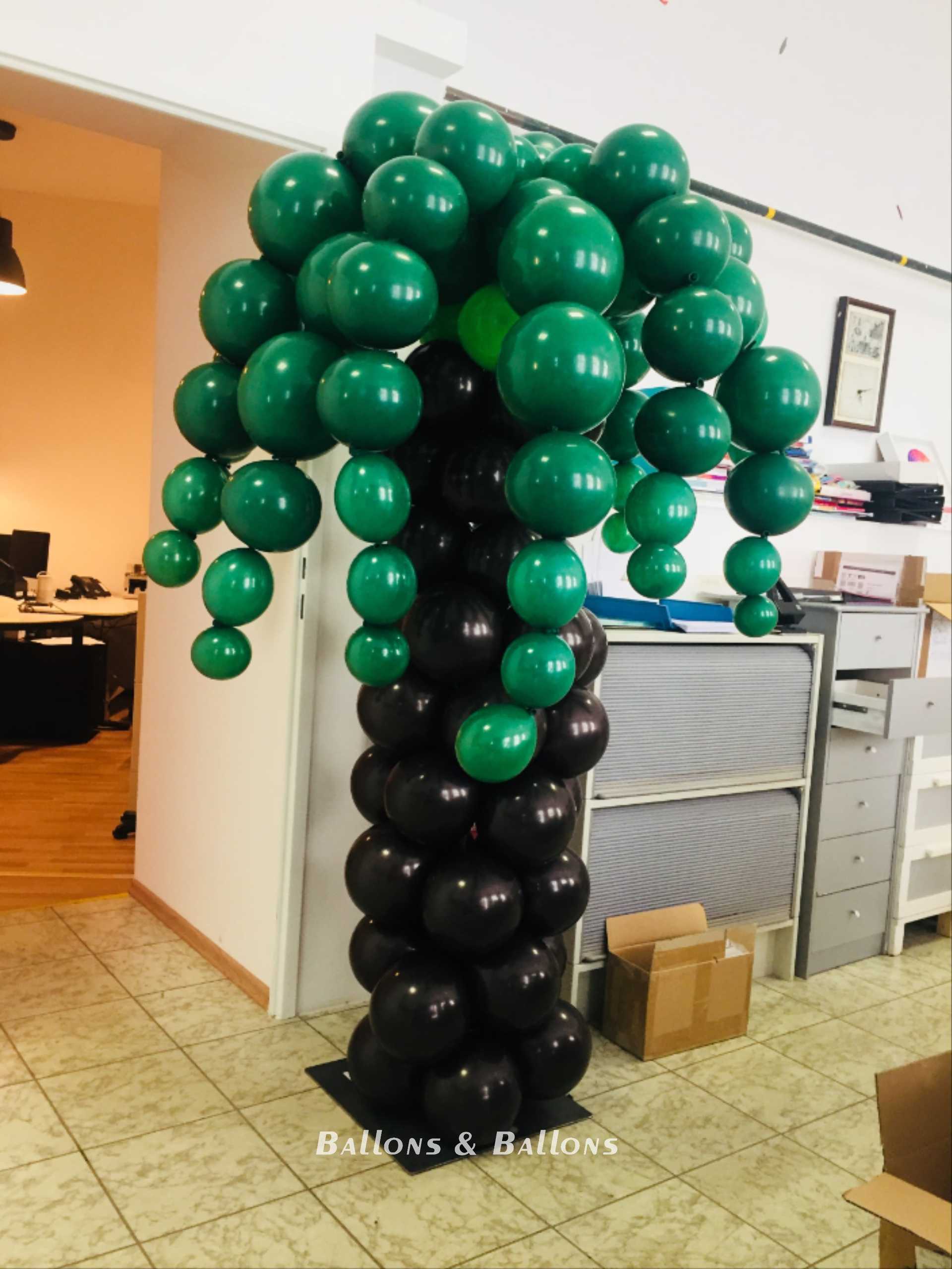 Ein grüner und schwarzer Ballonbaum in einem Raum in Wien.