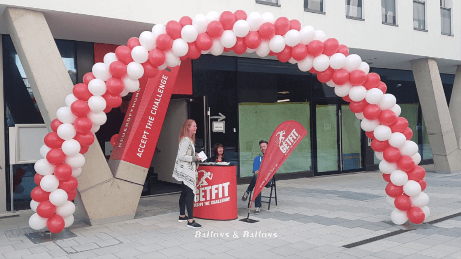 Zwei Frauen stehen unter einem großen roten Ballonbogen in Wien