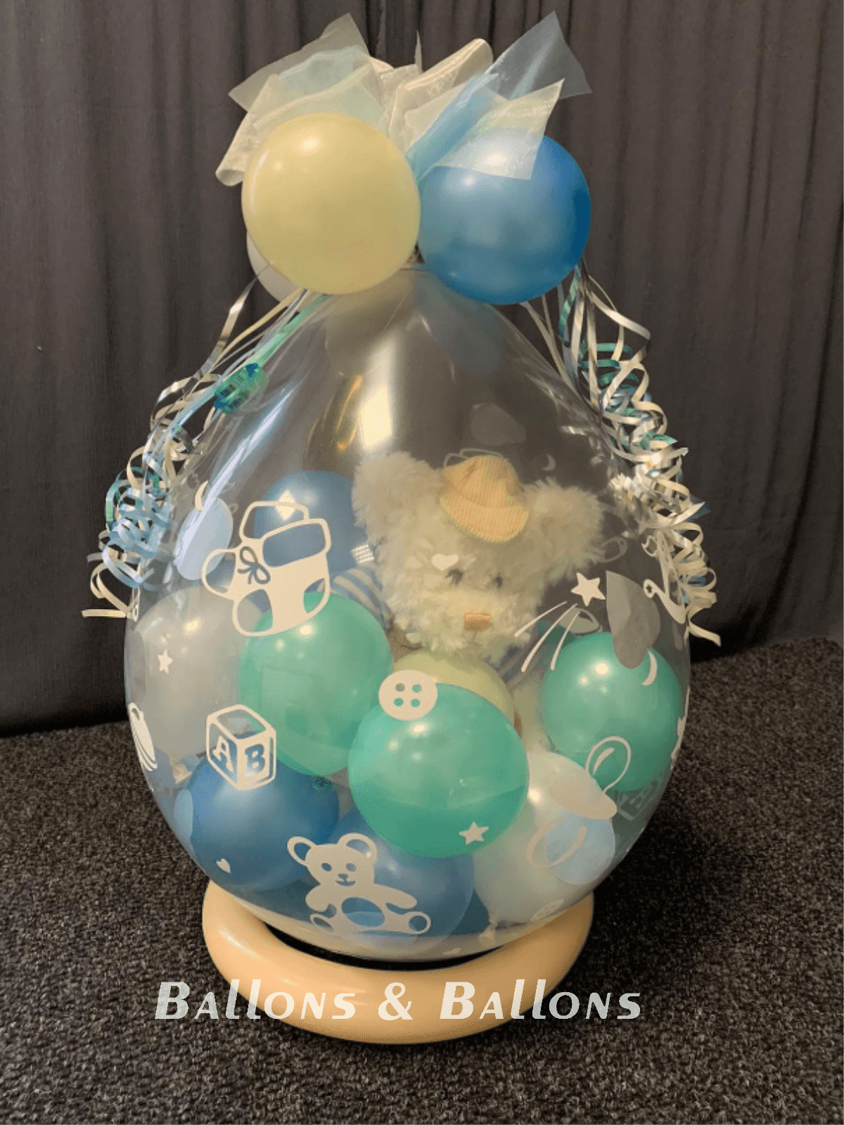 Ein großer Ballon mit einem Bären darin auf einem Holzständer.