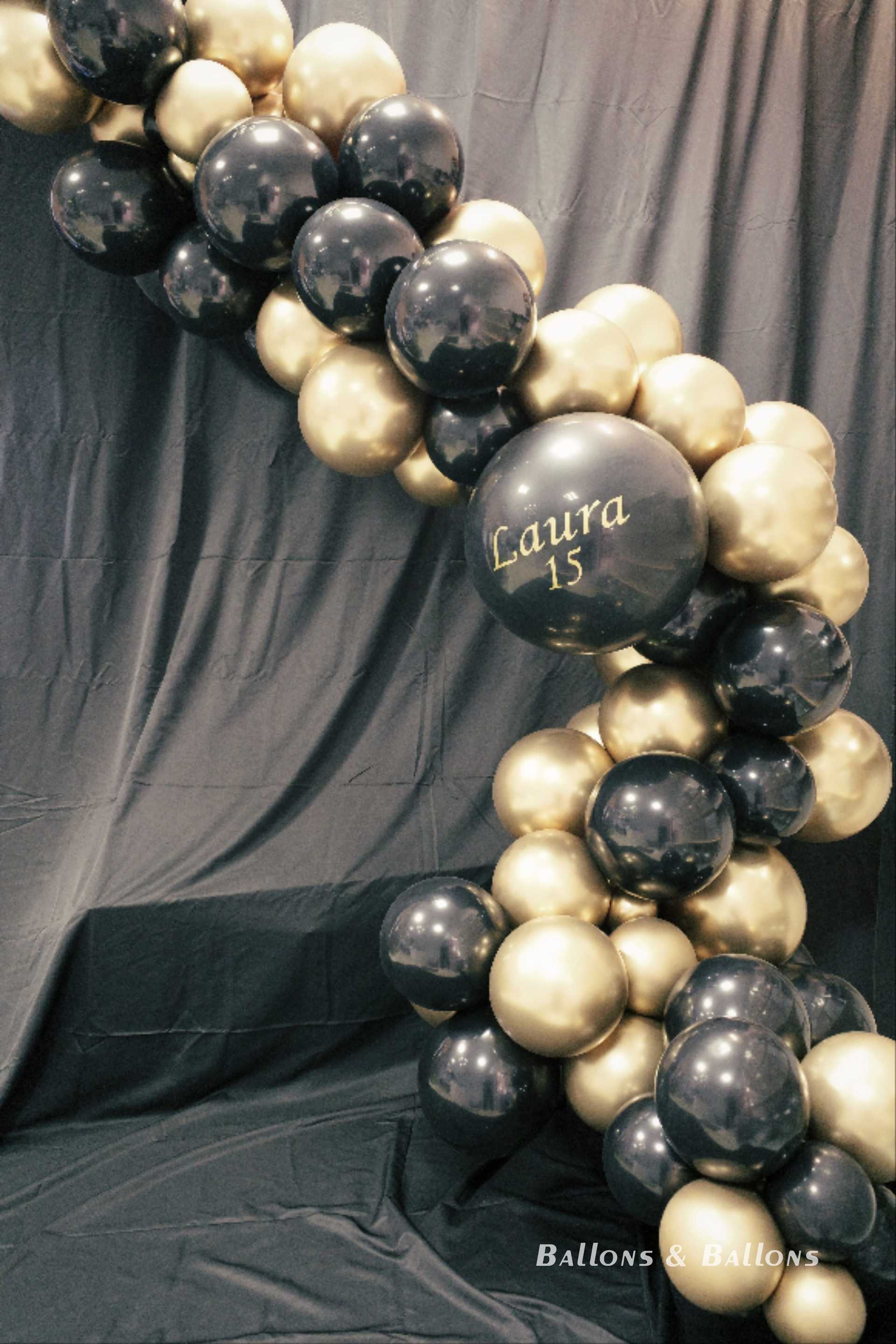 Eine schwarze und goldene Ballondekoration vor einem schwarzen Hintergrund