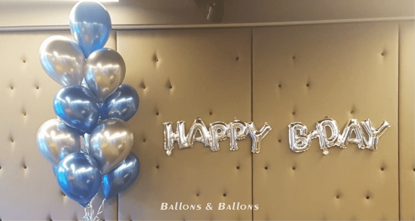 Zwei Ballons mit der Aufschrift Happy Birthday und viele silberne Ballons.
